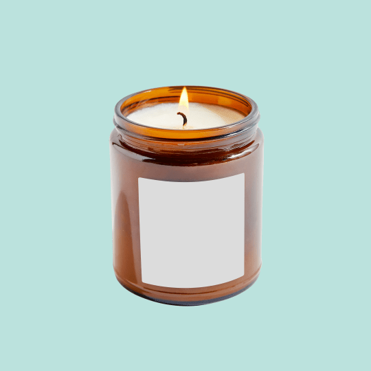 Velas em pote de vidro com etiqueta quadrada branca na frente. Fundo celestial