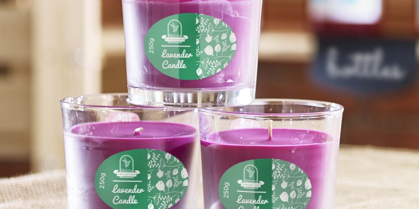 Três potes de vidro com velas roxas. Etiquetas adesivas personalizadas ovais verdes para potes