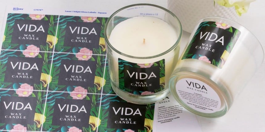Folha de etiquetas adesivas para velas com a inscrição "Vela de cera VIDA". Duas velas com etiqueta de amostra anexada