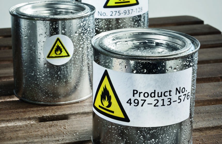 Latas de metal com etiqueta adesiva de poliéster branca indicando perigo de materiais inflamáve