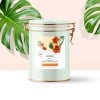 Pote de vidro com etiqueta adesiva plástica branca quadrada personalizada. Planta ao fundo como decoração