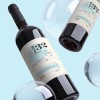 Garrafa de vinho de vidro com etiqueta adesiva retangular envolvente com informações do produto