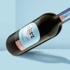 Garrafa de vinho de vidro com etiqueta azul claro e branco com informações do produto