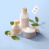 Dois frascos de cosméticos e um pote de creme com etiquetas adesivas personalizadas para cosméticos e plantas como decoração