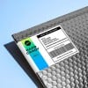 Etiqueta de envio personalizada anexada em envelope cinza