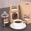 embalagens de café de papel e potes de vidro com etiquetas adesivas indicando o produto. xícara de café branca no centro