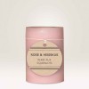 vela rosa com etiqueta redonda de papel na frente indicando o aroma e descrição